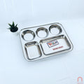 A rectangular stainless steel dinnerware set with multiple compartments, branded by VARUN, displayed on a white background with a small potted plant to the side.