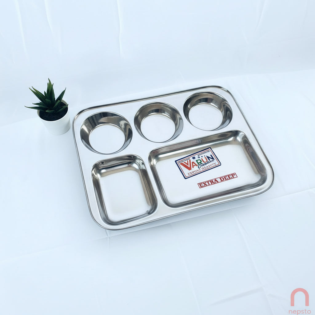 A rectangular stainless steel dinnerware set with multiple compartments, branded by VARUN, displayed on a white background with a small potted plant to the side.
