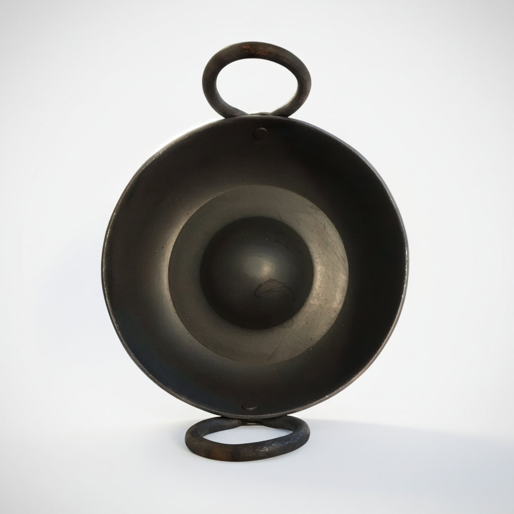 Black metal bowl with handle on a white background