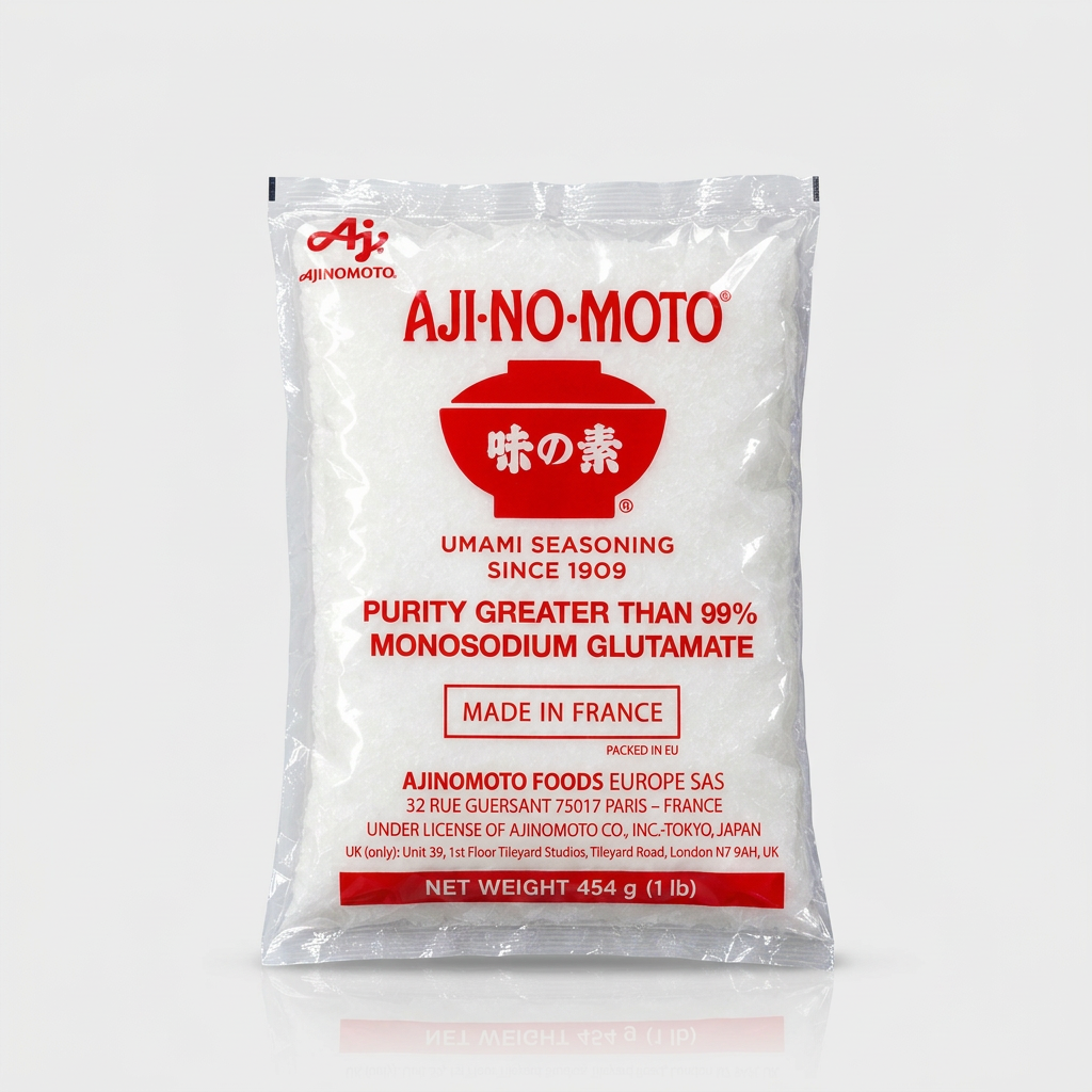 A 1 lb bag of Aji-No-Moto Umami Seasoning Monosodium Glutamate, in a clear plastic bag showing the white seasoning powder inside, with red and black text and logo on a light gray background.