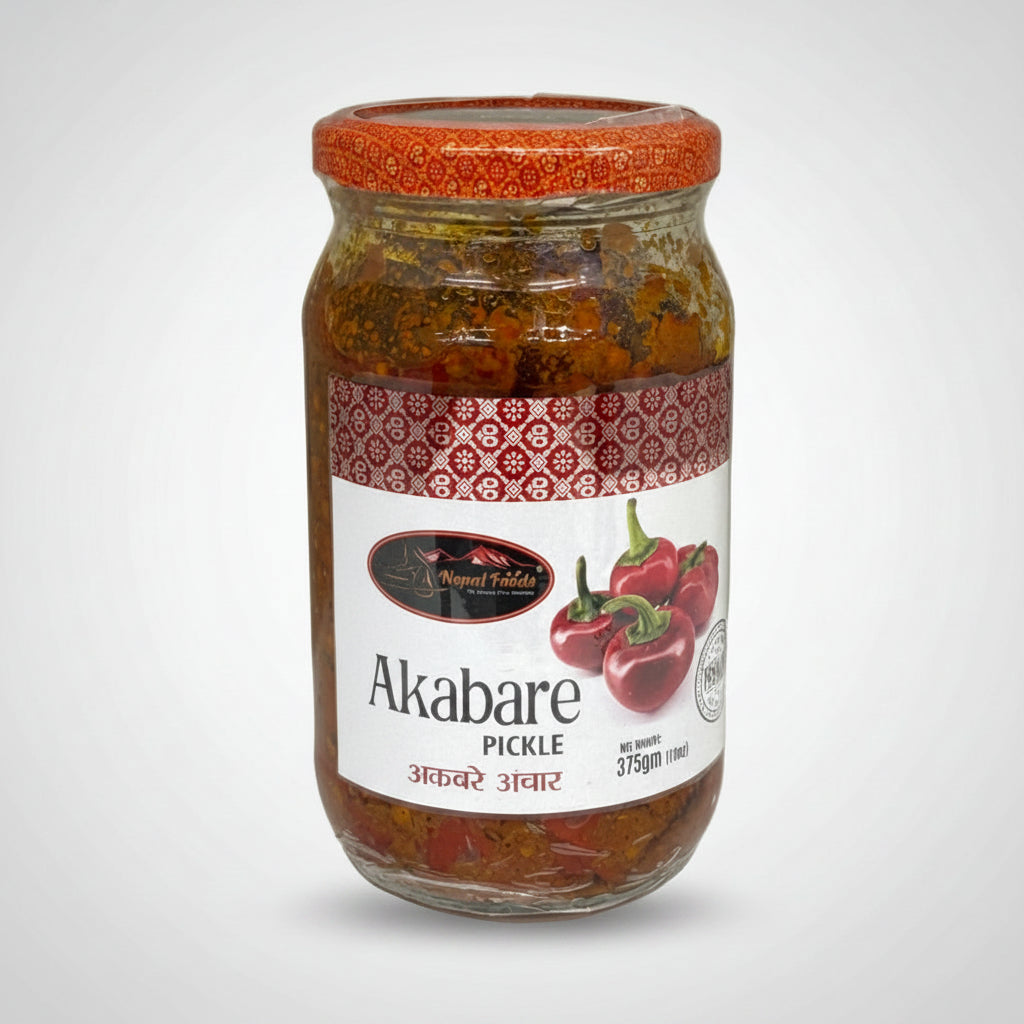 A glass jar of Akabare Pickle with a red patterned lid and a white label featuring red peppers, set against a plain white background.