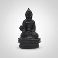Small black Buddha statue on a white surface with blurred background