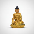 Gold Buddha statue on a white surface with a blurred background