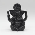 Black decorative figure of a person on a horse against a blurred indoor background