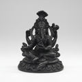 Black metal statue of a seated figure with a headdress on a white background