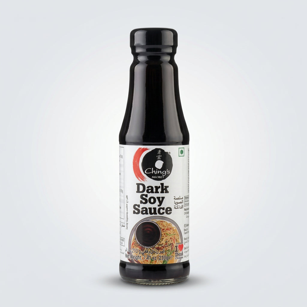 A bottle of Ching's Brand Dark Soy Sauce standing on a white counter with a blurred store background.