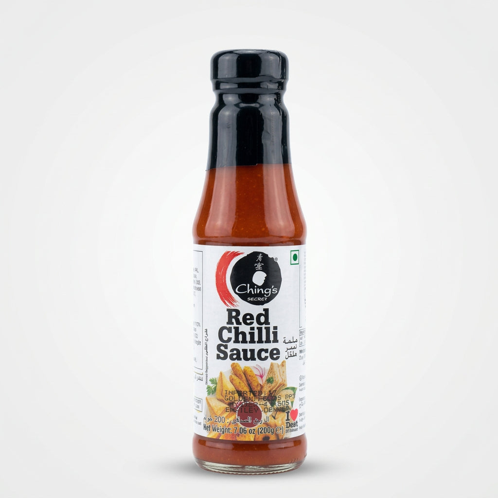 A bottle of Chettinad Red Chilli Sauce lying horizontally on a light-colored surface, with a blurred store background showing shelves and items.