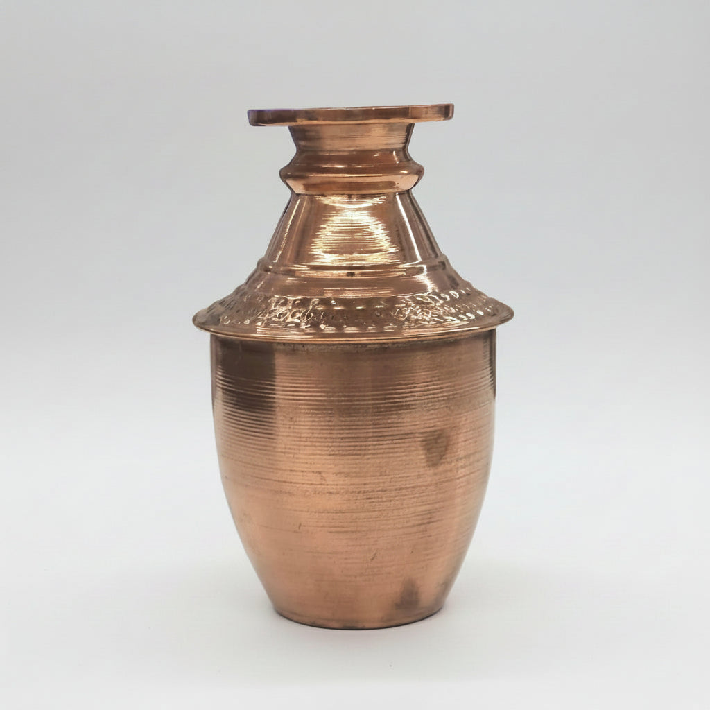 Copper vase with textured design on a white background