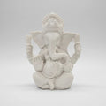 White decorative wall piece on a white wall with a blurred background