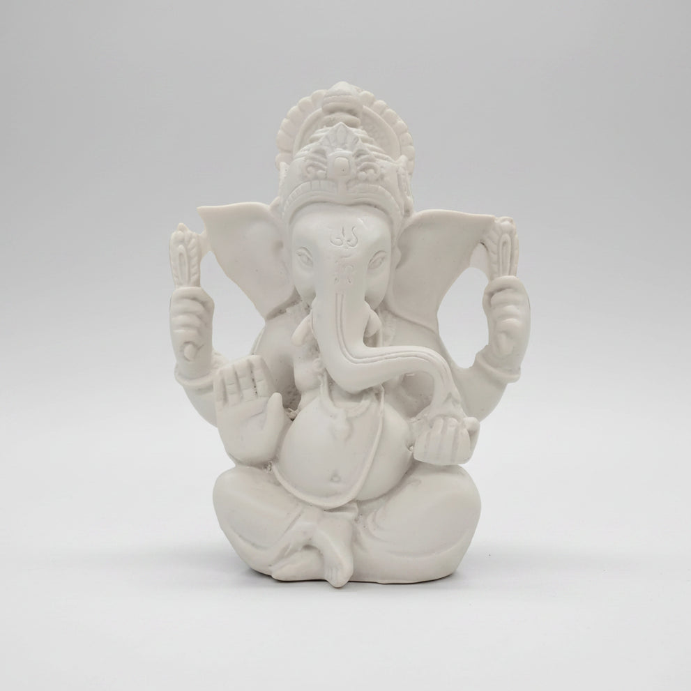 White decorative wall piece on a white wall with a blurred background
