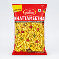 A packaged food product with branding 'Haldiram' visible on the top, labeled 'KHATTA MEETHA', indicating it is a sweet snack, 200g in weight, with a red and yellow color scheme.