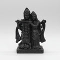 Black decorative wall sculpture against a blurred bookshelf background