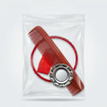 A red plastic comb and a red circular loop inside a clear plastic bag with a silver metal cap, photographed on a light gray surface.