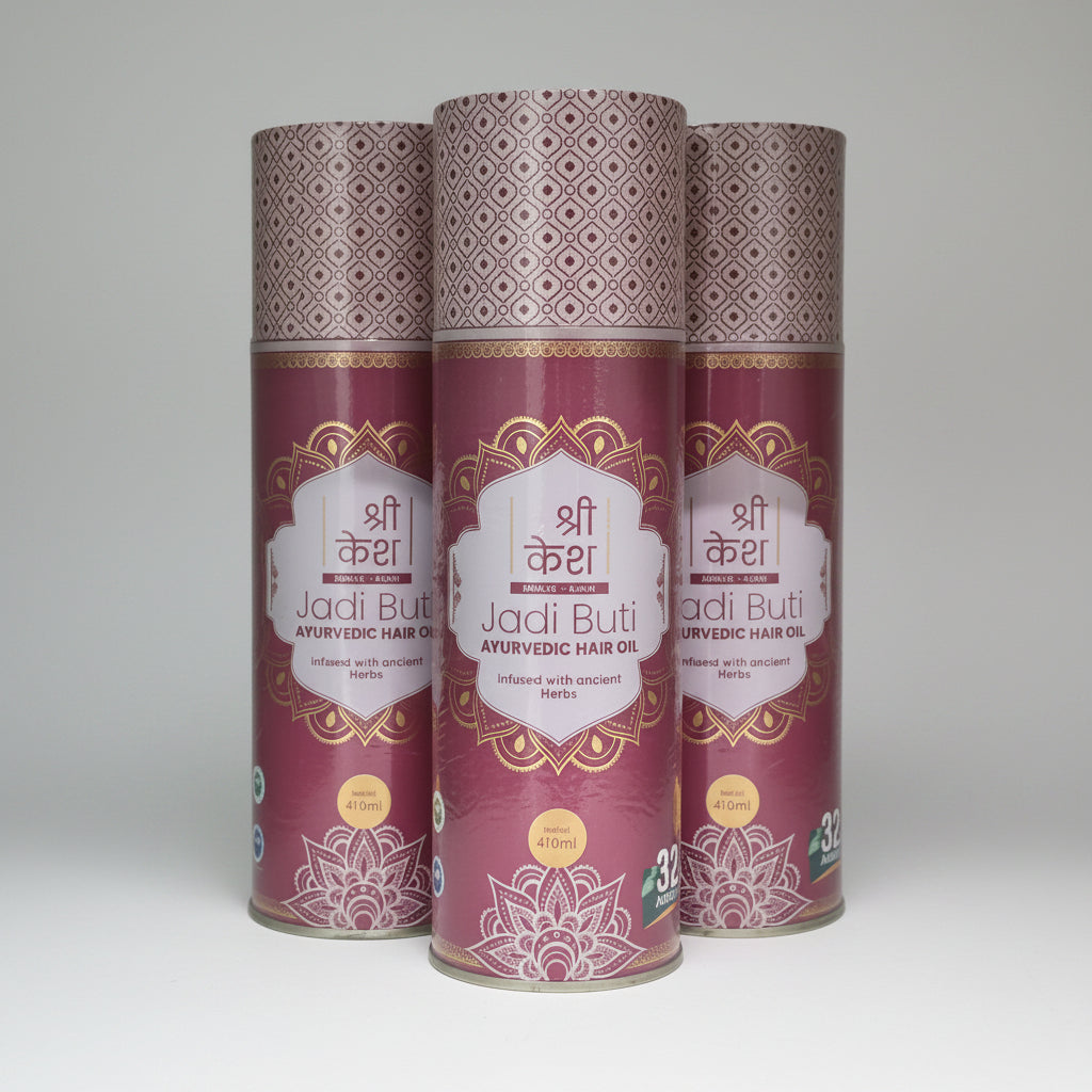 Three cans of 'Jadi But' Ayurvedic hair oil stacked on a white surface.