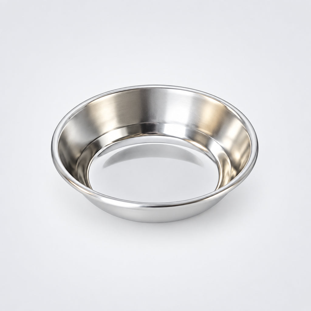 A small round metal serving plate on a white background with a reflective surface.