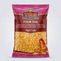 A package of TRS Toor Dal weighing 1kg. The packaging is primarily pink and yellow with an image of the dal seeds and some decorative patterns.