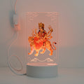 LED lamp with a depiction of a deity on a tiger, featuring a white base and power adapter.