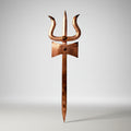 Copper trident on a gray background