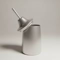 An aluminium cocktail shaker with a lid off to the side, placed on a white surface.