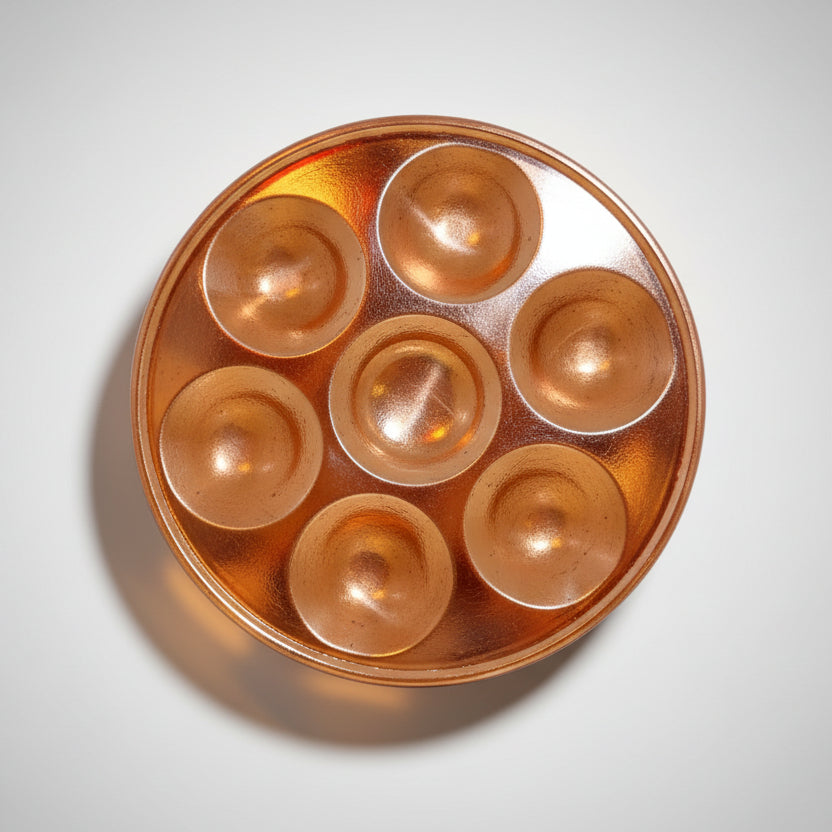 A silver-colored metal Puja Thali with multiple compartments displayed against a light blue background.