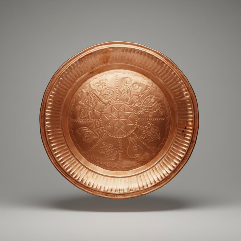 A decorative copper tray with embossed patterns displayed against a white background.
