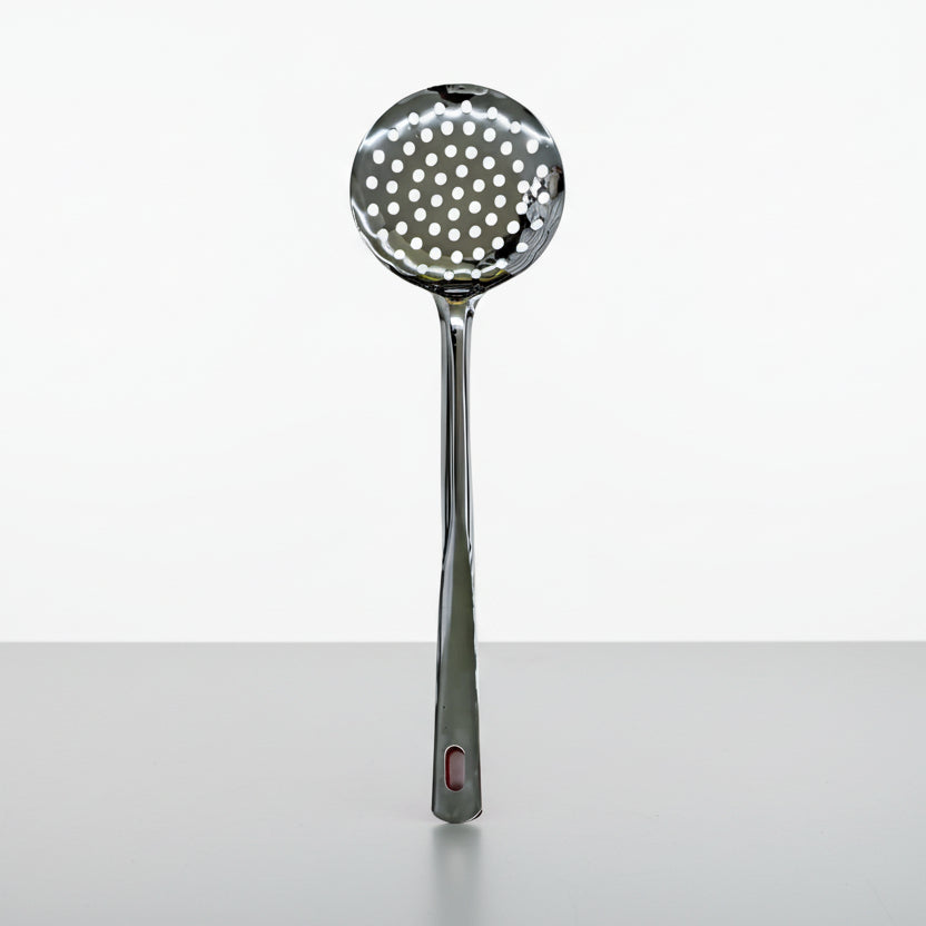 Metallic ladle with perforated spoon head on a white background