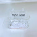 Clear plastic container with small items on a white background