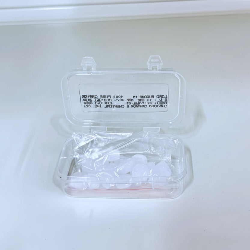 Clear plastic container with small items on a white background