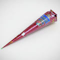 A cone-shaped container of mehendi (henna) with a decorative pattern, predominantly red with gold accents, used for body painting.