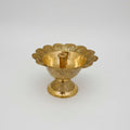 A gold-colored metal Akhanda Diyo candle holder with intricate designs displayed against a white background.