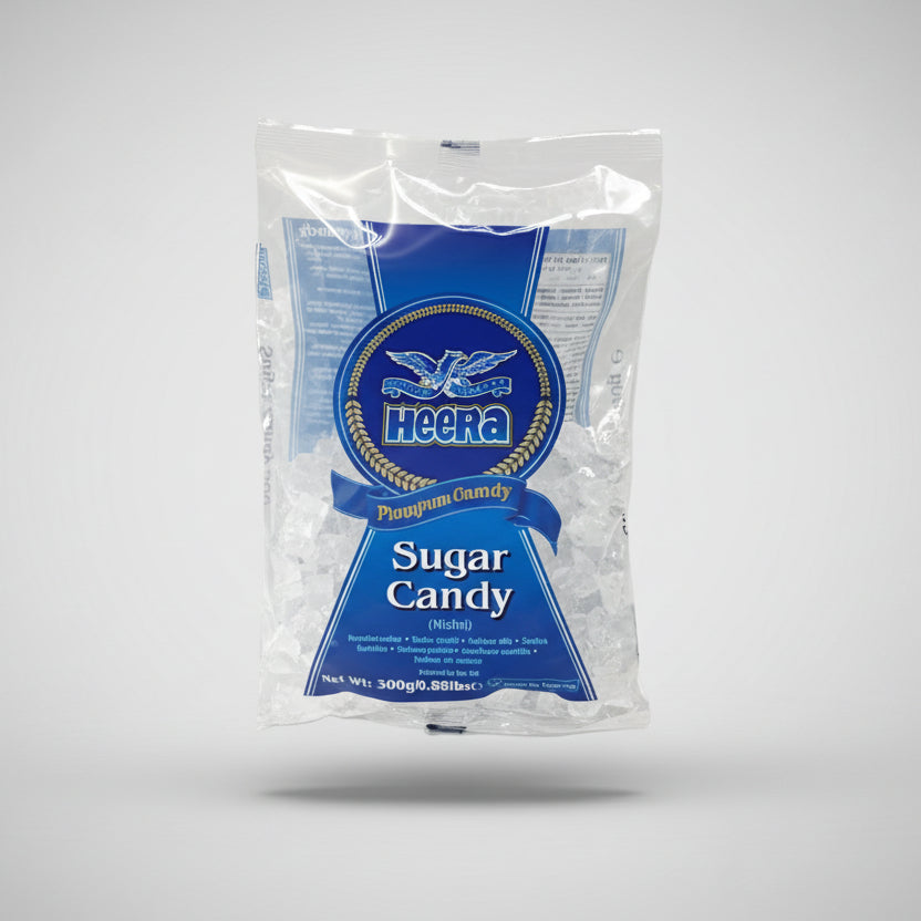 A sealed, white plastic packaging of Heera Sugar Candy with blue branding and text on it, placed on a reflective surface.