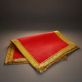 Red fabric with gold embroidery on a dark background