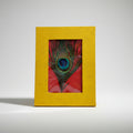 Yellow frame with a peacock feather on a white background