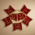 Red embroidered fabric pieces with gold lettering on a beige background