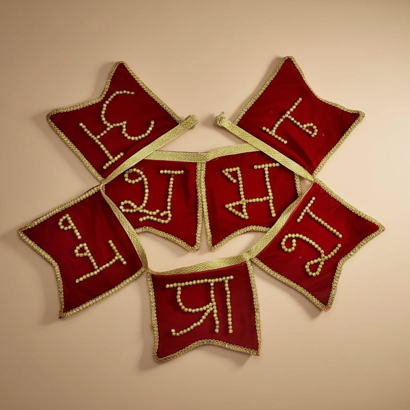 Red embroidered fabric pieces with gold lettering on a beige background